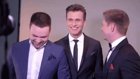 three men in suits and ties are standing next to each other smiling .