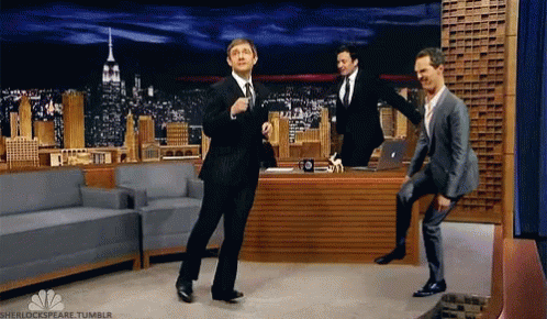 Three Men In Suits Are Dancing In Front Of Jimmy Fallon . GIF
