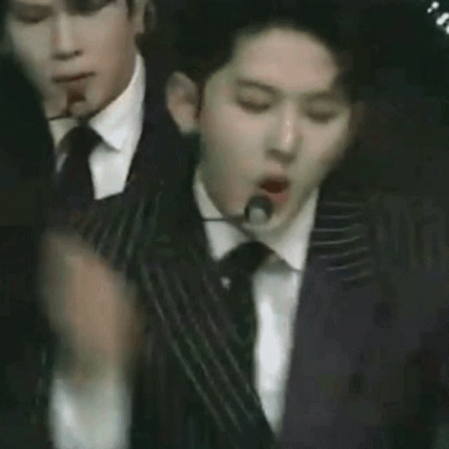 Three Men in Suits Dancing on Stage