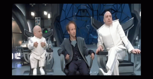 Three Men In White Suits Are Sitting In Chairs In A Futuristic Room GIF