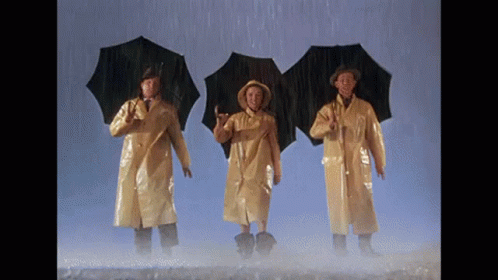 Three Men in Yellow Raincoats Holding Umbrellas