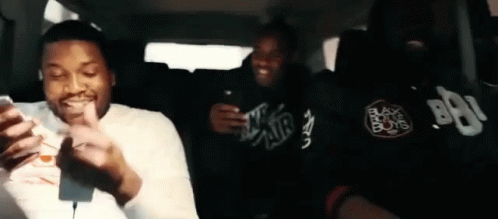 Three Men Looking at Phones in Back Seat