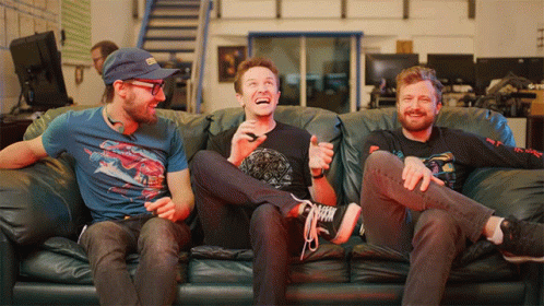 Three Men on Couch One Wearing Spiderman Shirt