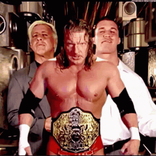 Three Men Posing With Championship Belt