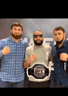 Three Men Posing With UFC Belt