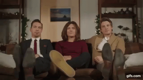 Three Men Sitting on Couch With Feet Up