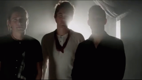 Three Men Standing In Dark Room GIF