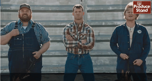 Three Men Standing in Front of Produce Stand