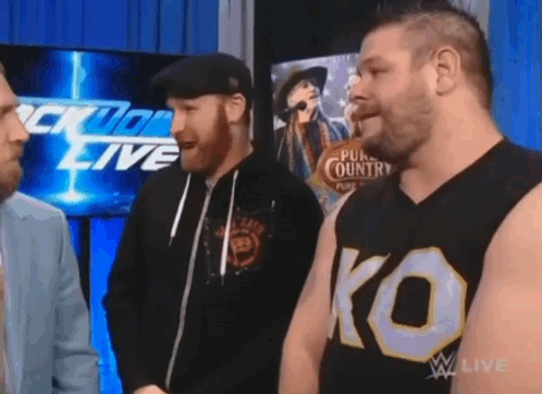 Three Men Standing in Front of Wrestling Live Screen