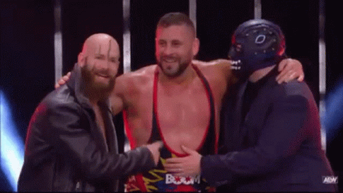 Three Men Standing on Stage One Wearing Mask