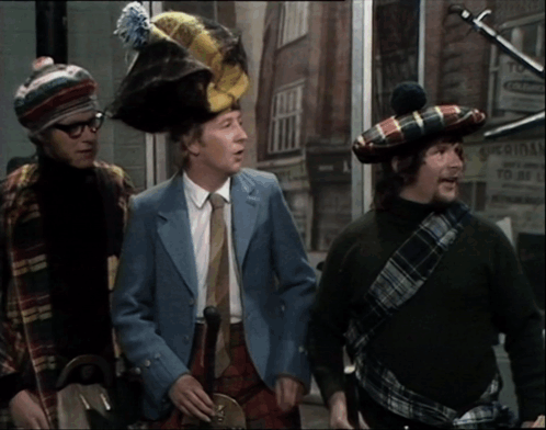 Three Men Wearing Kilts Are Standing In Front Of A Building That Says Original GIF