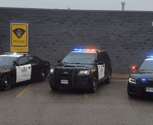 Three O.P.P. Police Cars Parked at Brick Building