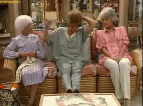 Three Older Women Are Sitting On A Couch In A Living Room . One Of The Women Is Wearing A Pink Shirt . GIF