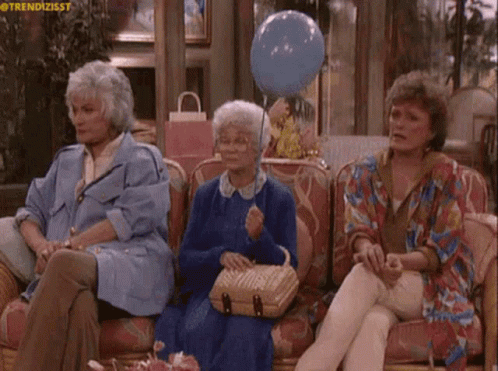 Three Older Women Are Sitting On A Couch With A Blue Balloon GIF