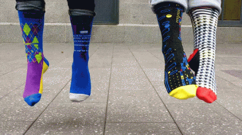 Three Pairs of Socks Hanging From Feet With Pac-Man