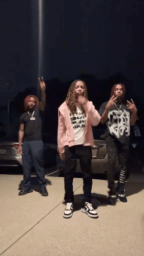 Three People Are Standing In Front Of A Car And One Of Them Has A Shirt That Says " I 'M A Rapper " GIF