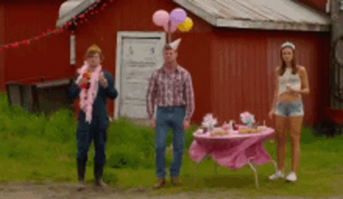 Three People Are Standing In Front Of A Pink Table With Balloons On It GIF