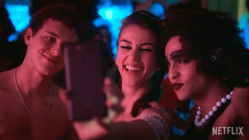 Three People Are Taking A Selfie With A Netflix Logo In The Background GIF