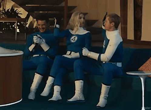 Three People In Fantastic Four Costumes Are Sitting On A Couch In A Living Room . GIF