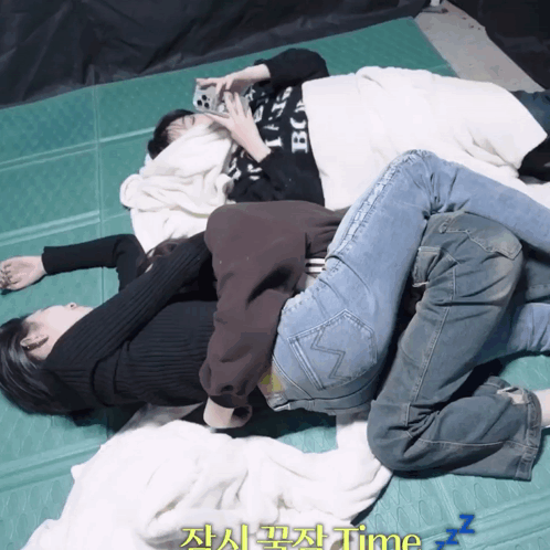 Three People Laying On Top Of Each Other On A Green Mat With The Word Time Written On The Bottom GIF