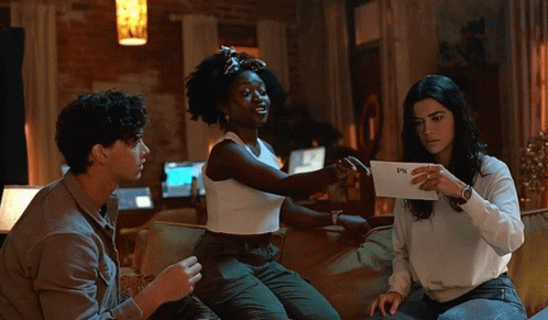 Three People on Couch One Holding Paper Saying PS