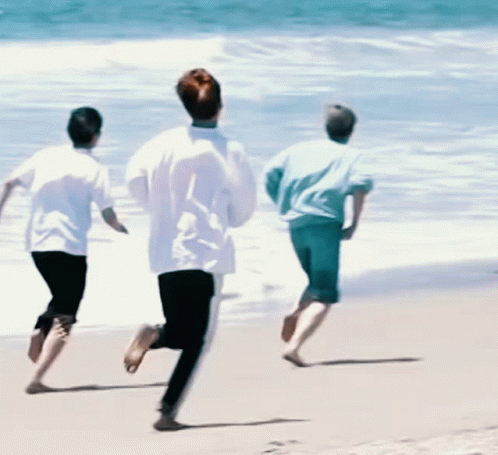 Three People Running on a Beach