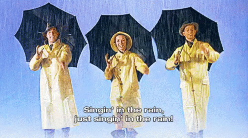 Three People Singin' in the Rain With Umbrellas