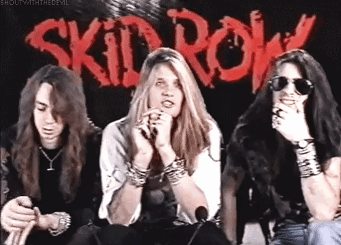 Three People Sitting Before Skid Row Sign GIF