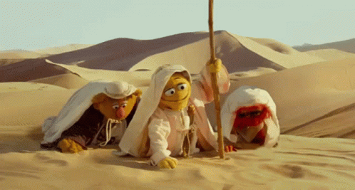 Three Sesame Street Characters Are Crawling Through The Sand GIF