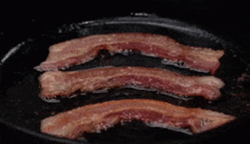 Three Slices Of Bacon Are Being Cooked In A Pan GIF