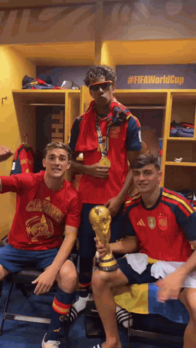 three soccer players are posing for a picture in a locker room with a sign that says #fifaworldcup