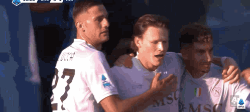 Three Soccer Players Hugging Number 27