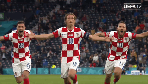 Three Soccer Players Wearing Red And White Checkered Jerseys With The Number 10 On The Front GIF