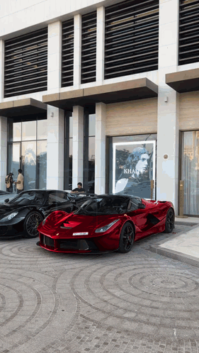 Three Sports Cars Parked in Front of Khan Sign