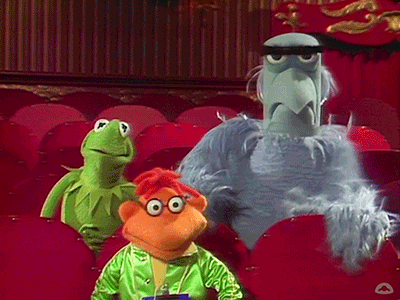 Three Stuffed Animals Are Sitting In A Theater Including Kermit The Frog And Sesame Street Characters GIF
