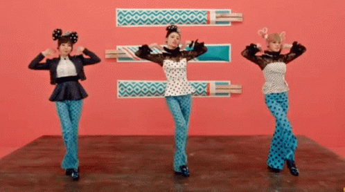 Three Women Are Dancing In Front Of A Pink Background GIF