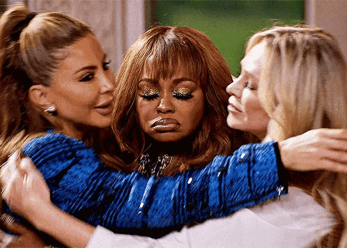 Three Women Are Hugging Each Other And One Of Them Is Wearing A Blue Top . GIF