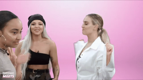 Three Women Are Standing In Front Of A Pink Background That Says Pop Blitz Meets On It GIF