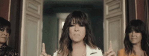 Three Women Are Standing Next To Each Other And One Is Pointing Up GIF