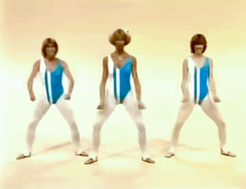 three women in blue and white swimsuits are standing in a row with their hands on their hips