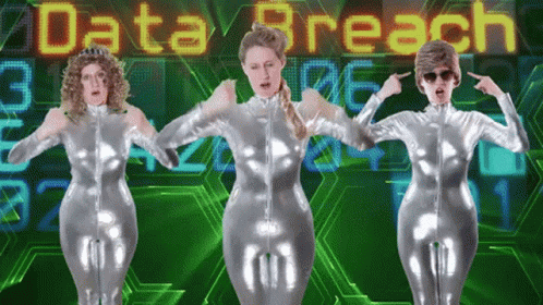 Three Women In Silver Jumpsuits Dance In Front Of A Screen That Says Data Breach GIF