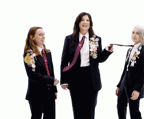 Three Women in Suits and Ties With Pins