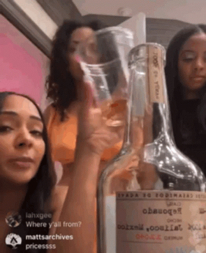 Three Women Next to Tequila Bottle