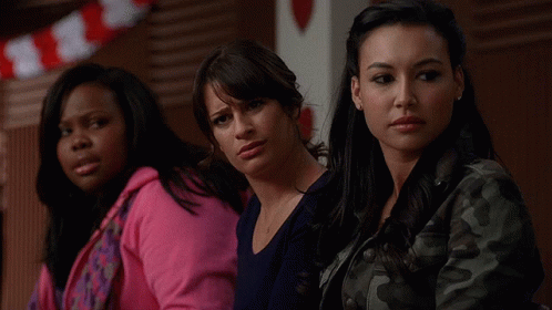 Three Women Sitting Together One in Pink Hoodie