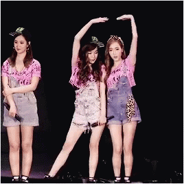 Three Women Stage Arms Up One Holding Mic