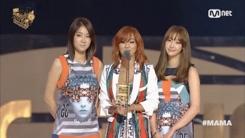 Three Women Stand On A Stage At A Mnet Event GIF
