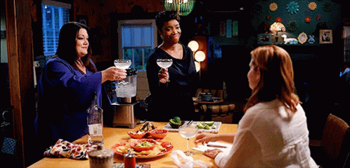 Three Women Toasting with Drinks and Food