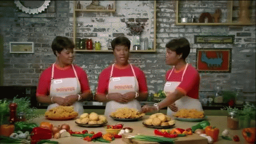 Three Women Wearing Aprons That Say Poivre Are Standing In A Kitchen GIF