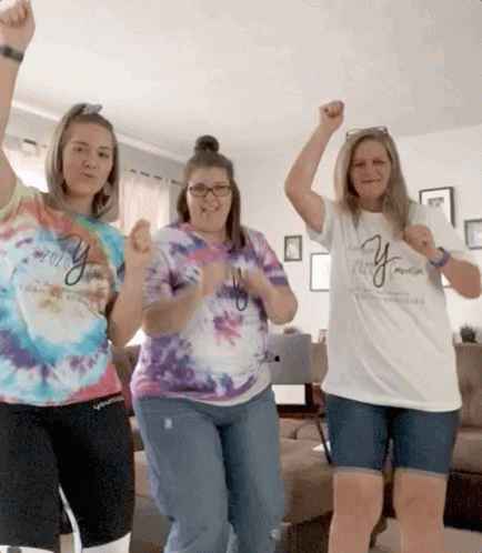 Three Women Wearing Tie Dye Shirts With The Word Young On Them Are Dancing In A Living Room GIF