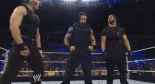 Three Wrestlers In A Wrestling Ring With A W Logo GIF